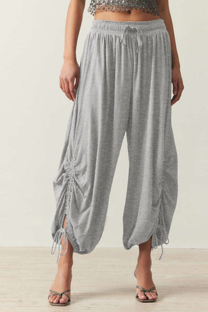 Gray gathered ankle-tie balloon trousers with drawstring waist and ruched detailing.