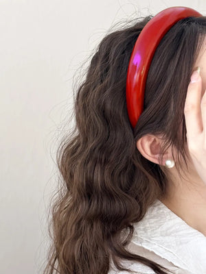 Glossy padded headband in deep red with a shiny finish.