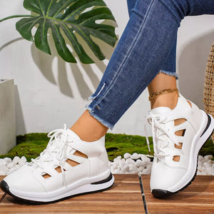 Chic white round toe lace-up sneakers with cut-out details and a black sole.