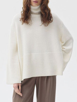 Ivory ribbed turtleneck sweater with flared sleeves and a wide ribbed hem.