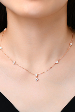 Rose gold necklace with diamond cluster pendant and scattered diamond accents.