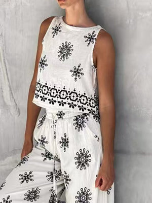 White two-piece set with medallion print, sleeveless crop top and drawstring pants.