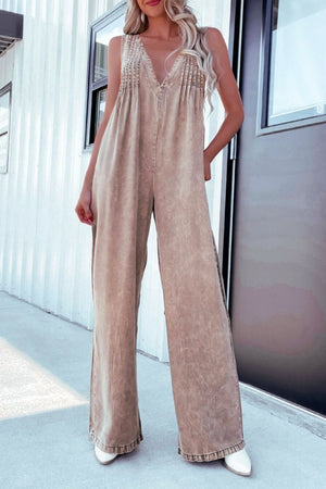 Khaki denim wide-leg jumpsuit with pleated bodice and ruffled hem.