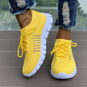 Yellow knit runner sneakers with white soles and stripe detail.