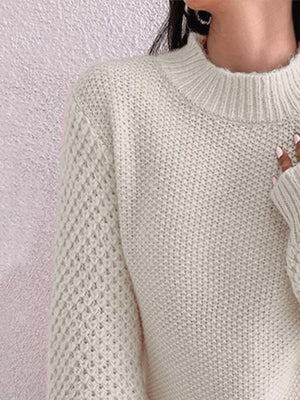 Cream acrylic knit sweater with mock neck and textured puff sleeves.
