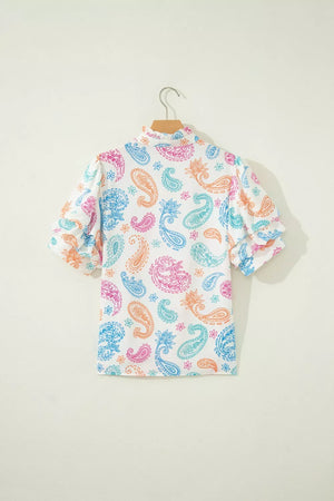 Maternity blouse with puff sleeves and vibrant paisley print in pink, blue, and orange on white.