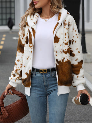 Brown cowhide print sherpa zip-up hoodie with white trim and hood.