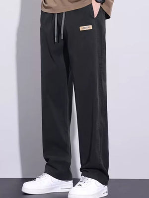 Black relaxed fit men's sweatpants with drawstring and logo patch