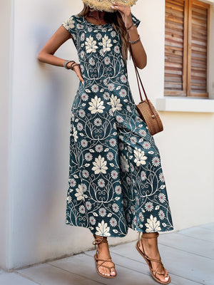 Dark green botanical print culotte jumpsuit with short sleeves and wide legs.