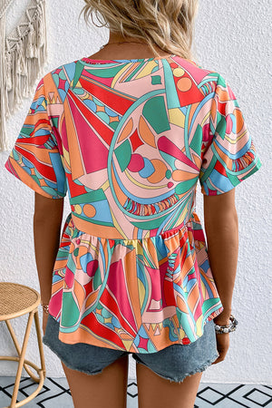Multicolor geometric print peplum blouse with short sleeves and tassels.