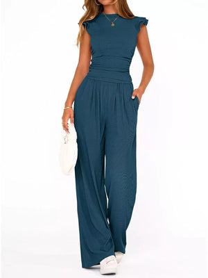 Teal ruffled cap sleeve maternity jumpsuit with crew neck and wide leg pants.