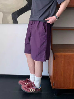 Men's purple lightweight drawstring shorts with pockets, styled casually.