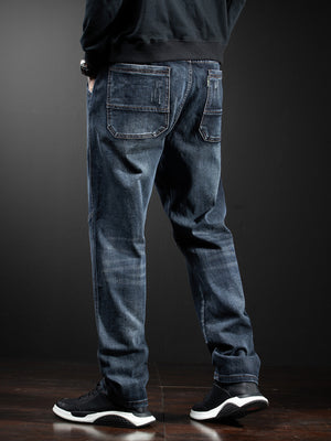 Men's dark wash loose fit cotton jeans with distressed details and drawstring waist.