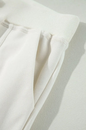 Ivory cargo pants with wide leg silhouette and side pockets.