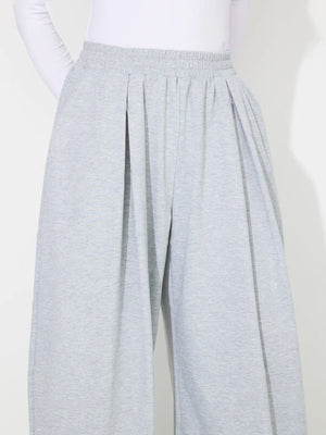 Light gray pleated drape palazzo trousers with elastic waistband and wide leg.