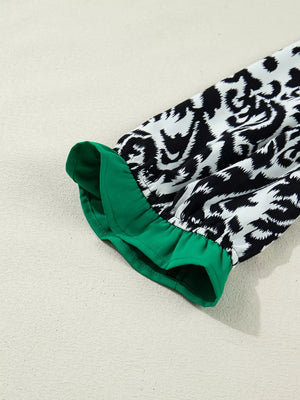 Maternity blouse with damask print, green ruffled cuff, and half-sleeves.