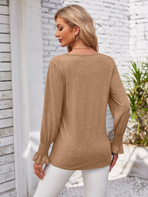 Camel blouson sleeve top with smocked cuffs and V-neck detail.