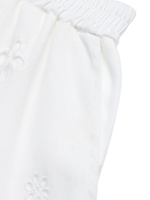 White embroidered lace trim pocketed shorts with elastic waistband.