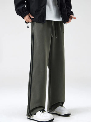 Gray green cotton sweatpants with black side stripes and drawstring waist.