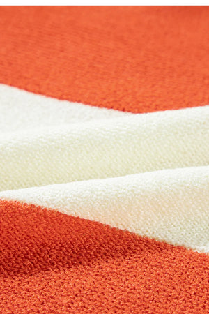 Orange and cream striped acrylic knit sweater with a V-neck.
