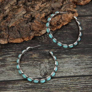 Textured turquoise stone hoop earrings with silver-tone alloy setting.
