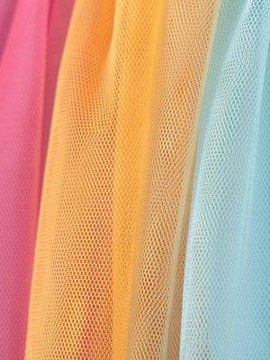 Toddler rainbow tulle dress fabric detail in pink, orange, and blue.