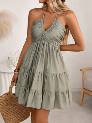 Olive green ruched halter tiered mini dress with ruffles and a V-neckline.