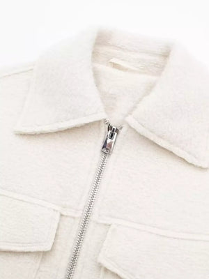 White cropped zip-up jacket with collar and two chest pockets.