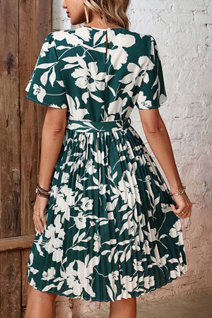Forest green floral midi dress with flutter sleeves, belt, and pleated skirt.