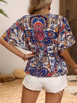Paisley print peplum blouse in royal blue with short sleeves and a cinched waist.