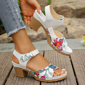 White floral open-toe block heel sandals with adjustable strap.