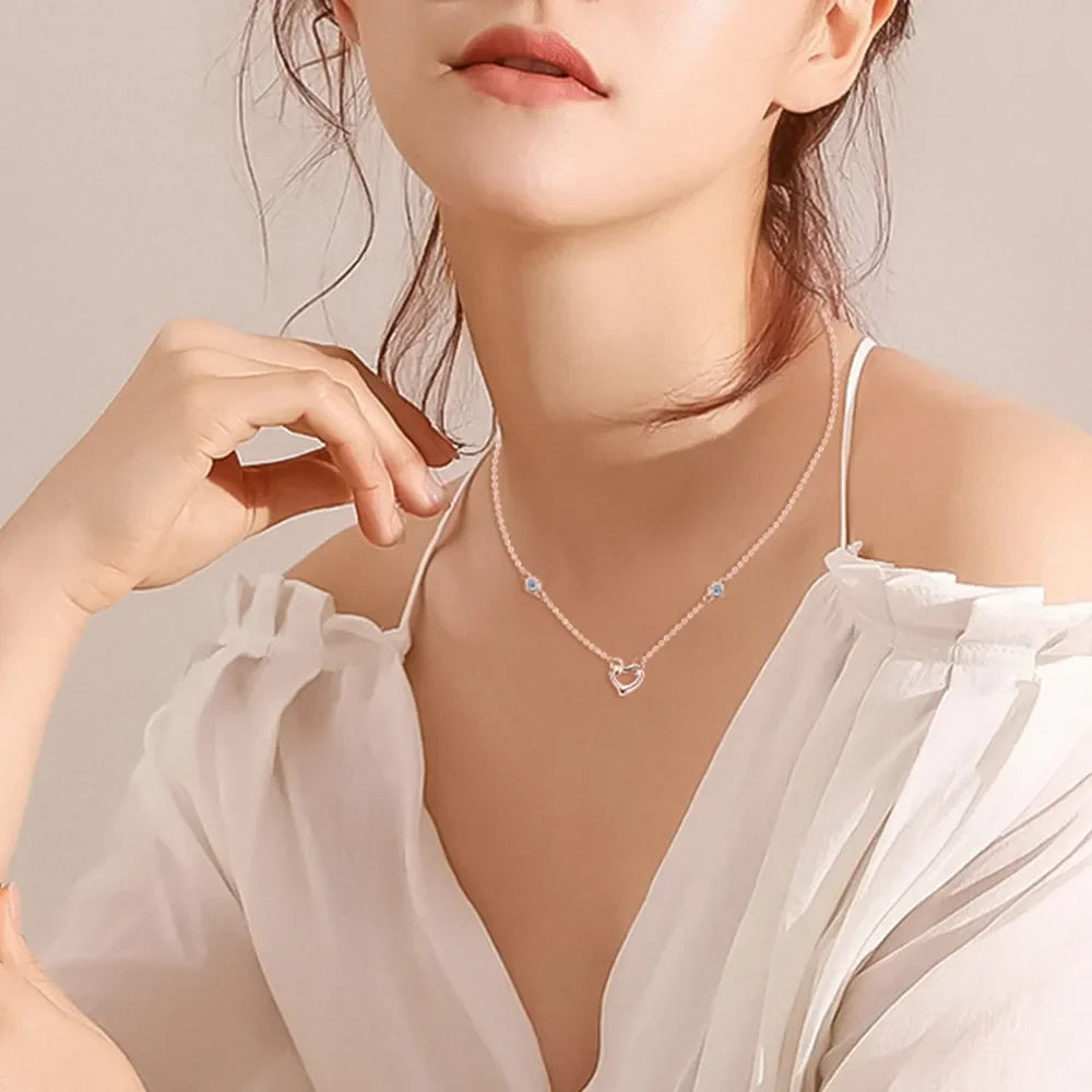 Rose gold linked heart pendant necklace with blue stone accents.