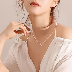 Rose gold linked heart pendant necklace with blue stone accents.