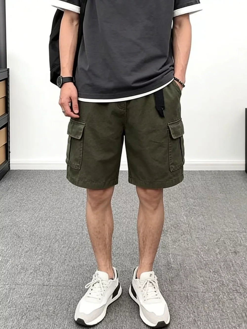 Men's green cotton cargo shorts with multiple pockets and a black belt.