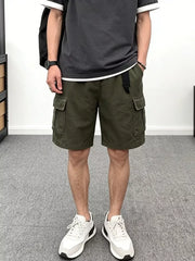 Men's green cotton cargo shorts with multiple pockets and a black belt.
