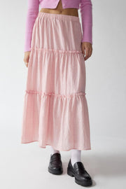 Tiered cotton maxi skirt in blush pink with ruffled tiers and an elastic waistband.