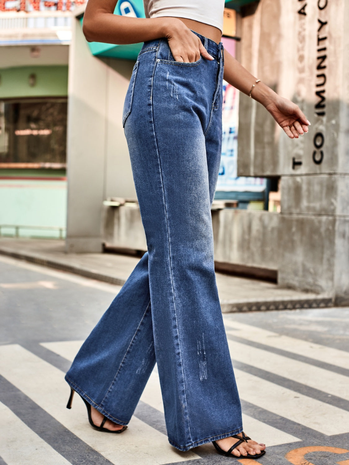 Dark blue denim flare jeans with distressed details and a high waist.