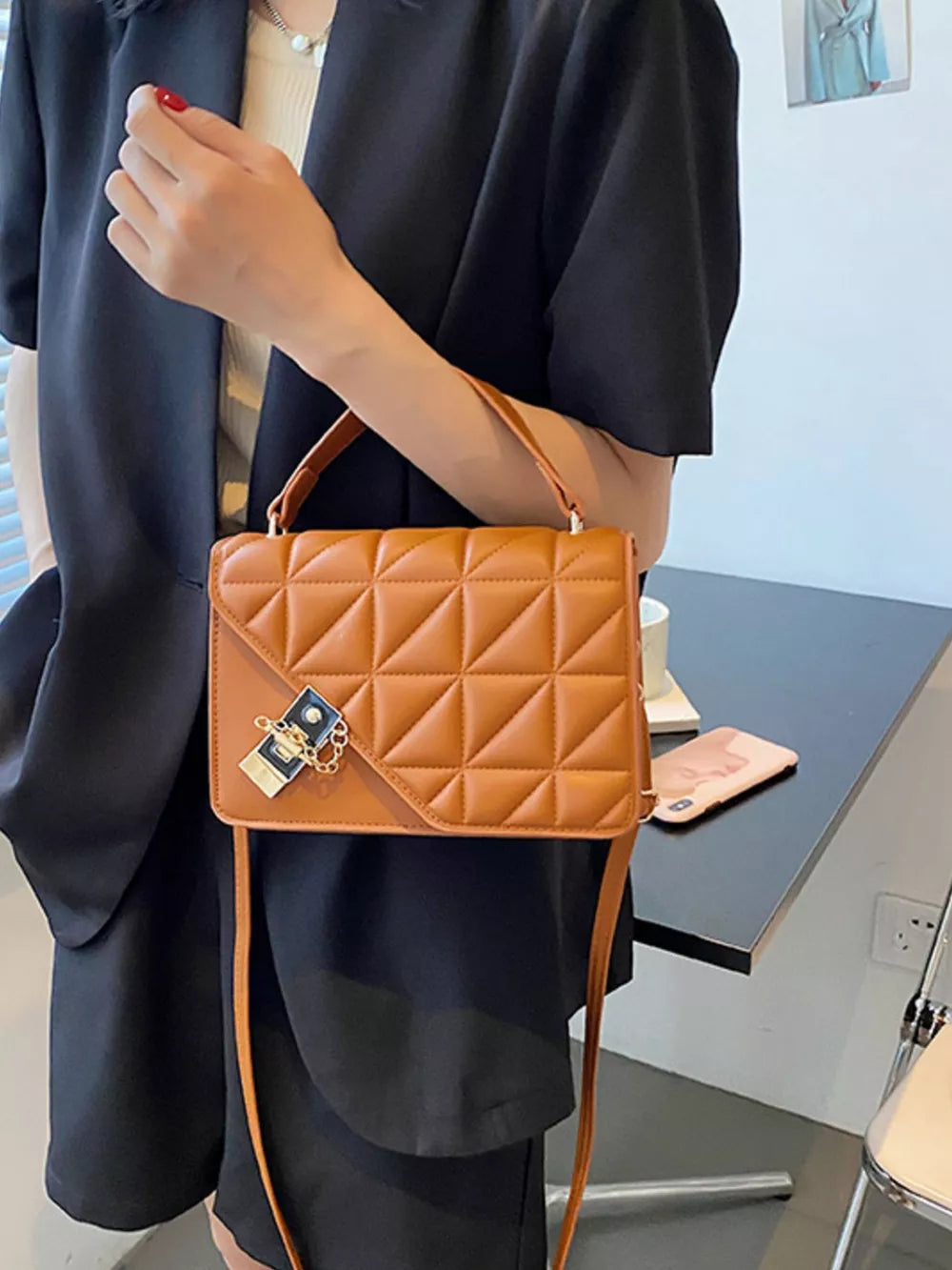 Diamond quilted PU leather crossbody bag in caramel with gold chain detail.