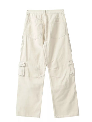 Cream cargo pants with buttoned multi-pocket design and wide leg cut.