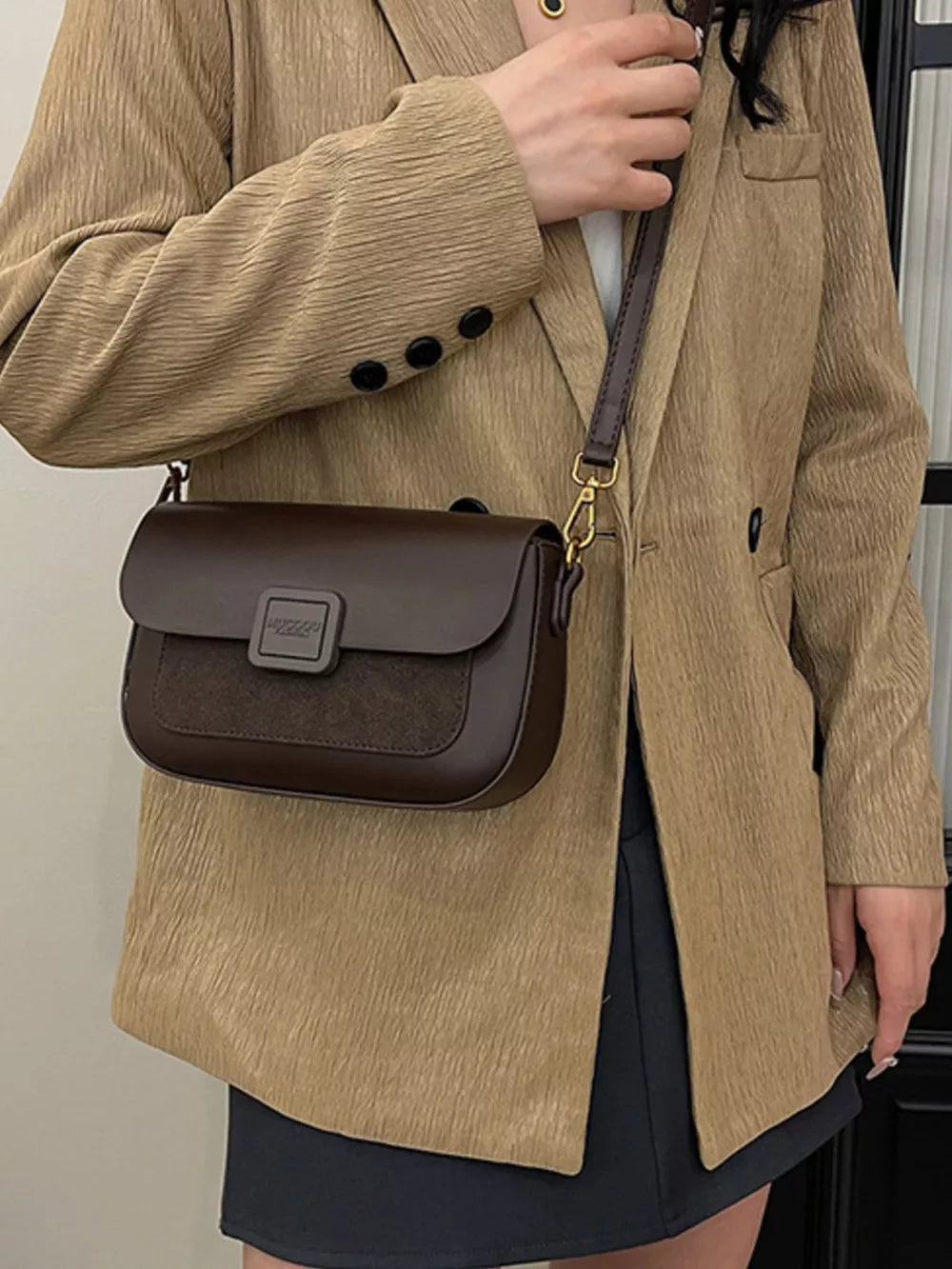 Chic two-tone crossbody bag in coffee brown with suede panel and flap closure.