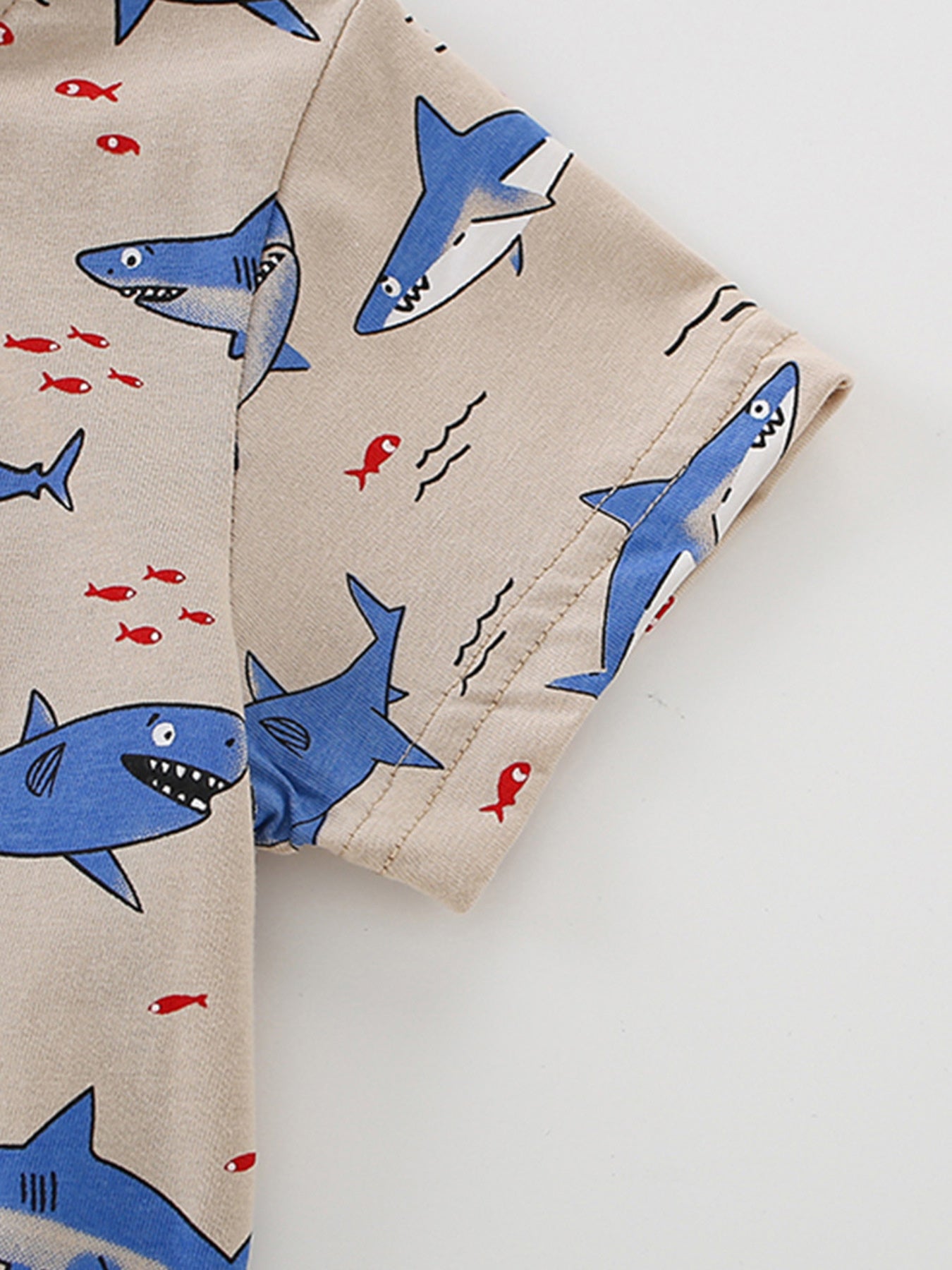 Toddler crew neck t-shirt in beige with blue shark and red fish print.