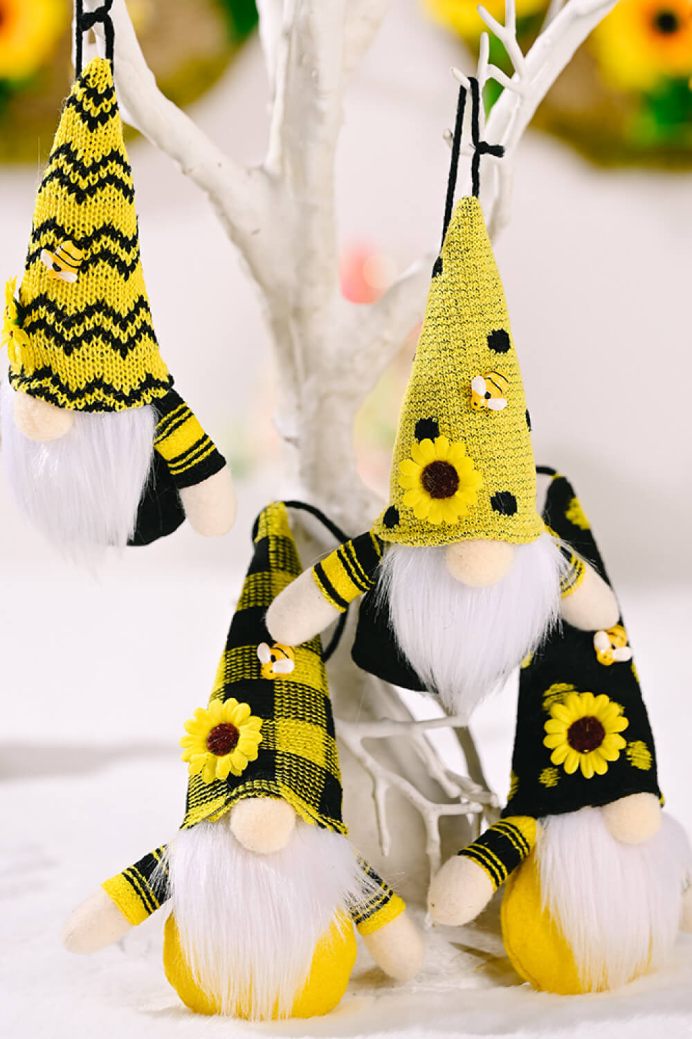 Bee-themed gnome ornaments in yellow with sunflowers and bee accents, featuring white beards and striped sleeves.