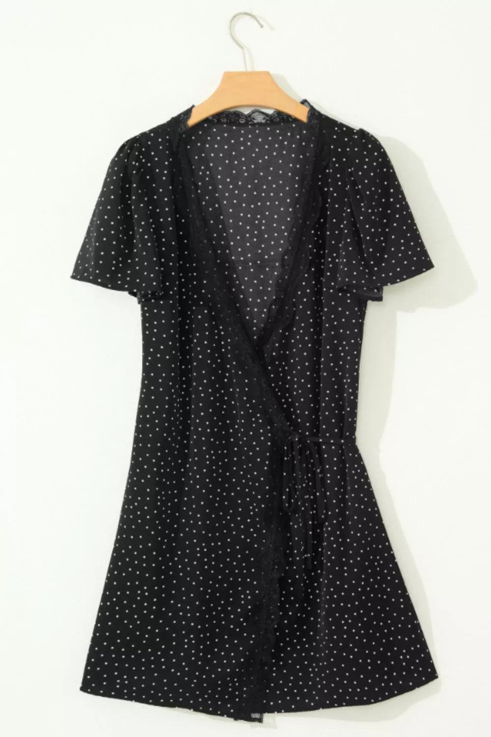 Black polka dot wrap mini dress with lace trim and flutter sleeves.