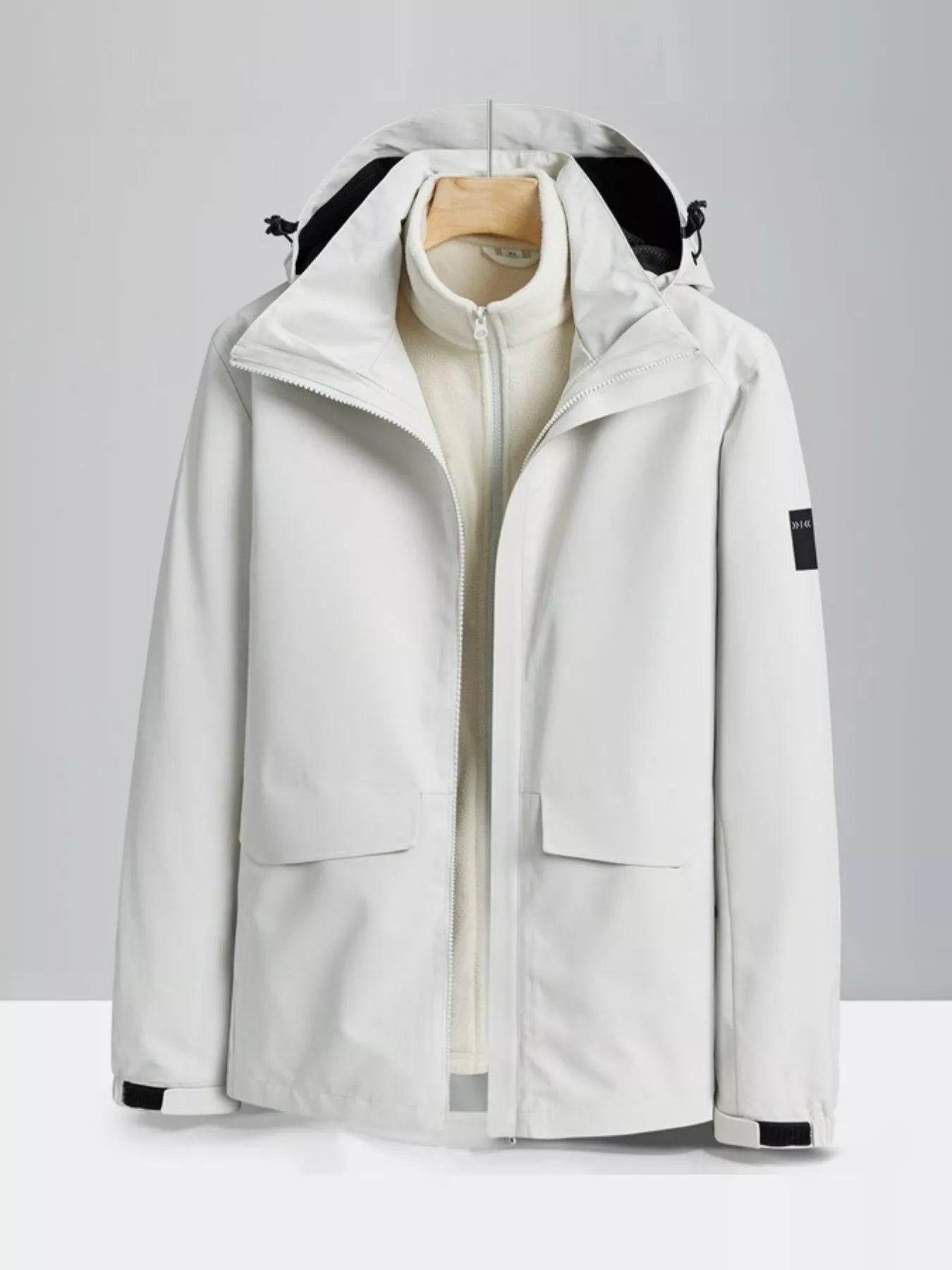 White hooded waterproof jacket with zip-out fleece liner and two front pockets.