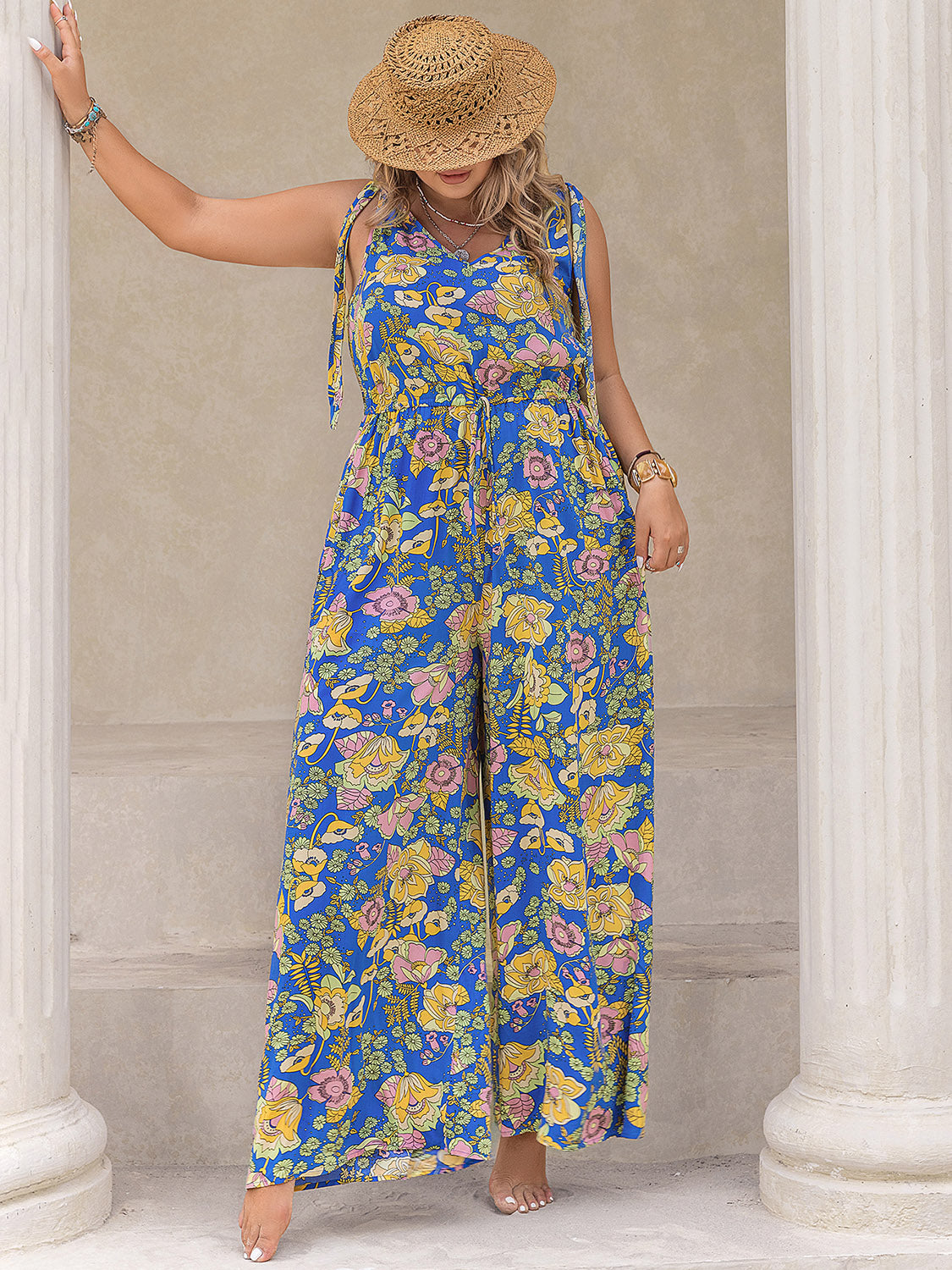Blue floral tie-shoulder wide-leg jumpsuit with drawstring waist and V-neck.