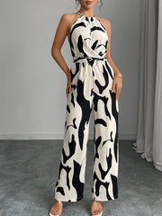 Chic abstract print halter jumpsuit in black and white with a tie waist and wide legs.