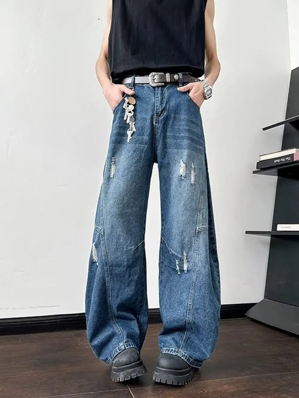 Distressed oversized wide-leg jeans in dark blue denim with ankle length and casual styling.