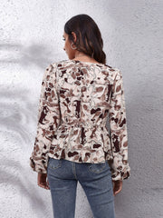 Beige abstract print peplum blouse with gathered waist and long sleeves.