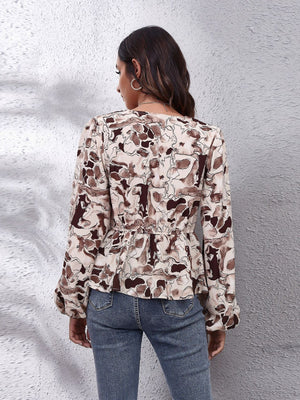 Beige abstract print peplum blouse with gathered waist and long sleeves.