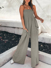 Gray smocked wide leg romper with pockets and spaghetti straps.
